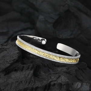 Two-tone S925 sterling silver cuff bracelet with gold floral engraving on dark background