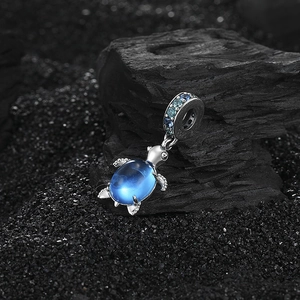 Elegant S925 sterling silver sea turtle pendant with blue zircon on dark coal background