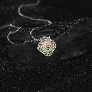 Elegant s925 silver two-tone petal necklace with red zircon stone on dark charcoal