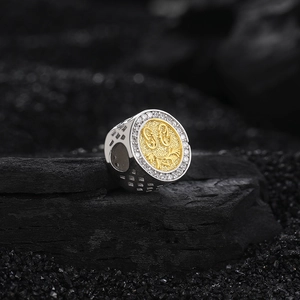 Two-tone punk signet ring with gold embossed center and pave zircon halo on dark stone