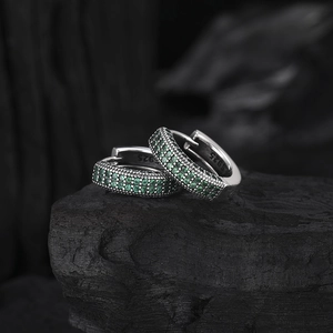S925 sterling silver hoop earrings with pave-set green zircon on a dark stone background