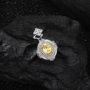 Macro view of s925 silver flower pendant with yellow oval gem and brushed texture