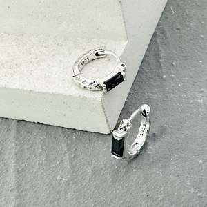 Detail of S925 silver earring featuring black zircon stones and textured meteorite finish