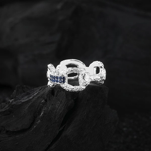 Détail macro d'une bague en argent S925 avec zircons bleus et motifs baroques
