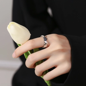 Elegant s925 silver heart ring with blue zircon stones held against a white tulip