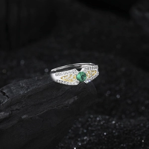 S925 sterling silver angel wing ring with round green zircon on textured charcoal background