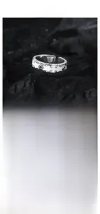 Macro detail of S925 sterling silver ring with white enamel and vintage floral pattern