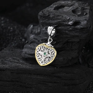 S925 silver heart pendant with golden filigree and green gemstone on dark background