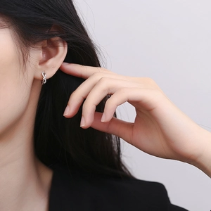 Boucles d'oreilles nœud en argent S925 avec zircons pavés portées par un mannequin