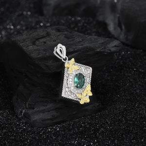 S925 silver butterfly pendant with green zircon and vintage relief on dark background