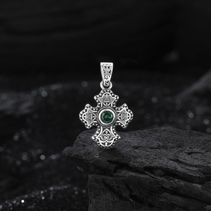 Retro s925 silver cross pendant with green gemstone on charcoal stone background