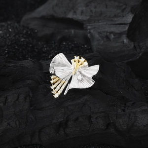 S925 silver skirt pendant with golden accents and crystals on dark textured background