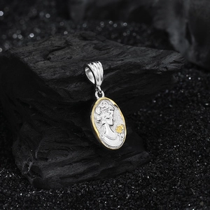 Macro shot of s925 silver oval relief pendant with a golden flower and female portrait
