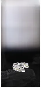 Detail of two-tone feather ring with gold accents and engraved silver texture