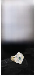 Detail of s925 silver honeycomb ring with green gemstone and gold-plated floral carving