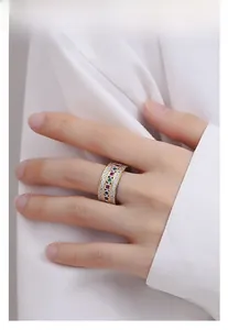 Detail of three-row silver ring with colorful crystals and gold plating on model finger