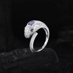 S925 Sterling Silber Schlangenring mit lila Zirkonia und grünen Augen auf schwarzem Fels