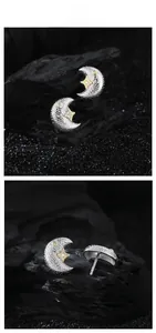 Detail of silver crescent moon earrings with gold star and sparkling zircon stones