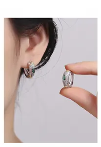 Detail of S925 silver vintage earrings with gold flowers and green gemstones