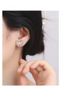 Macro shot of S925 silver celestial stud earring with gold star and zircon moon