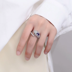 Schlangenring aus Sterlingsilber mit violettem Stein und grünen Augen am Zeigefinger