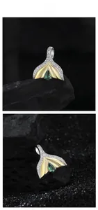 Macro detail of S925 silver mermaid tail pendant with emerald zircon and two-tone finish