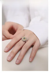 Detail of S925 silver two-tone clover ring with green zircon on model finger