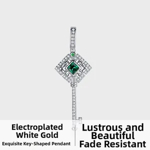 Détail du pendentif clé en argent avec une pierre verte et des cristaux brillants