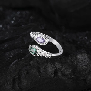 Adjustable S925 silver ring with oval purple and green gems on a dark stone background