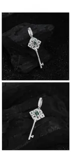 Gros plan sur pendentif clé en argent avec pierre verte carrée et détails brillants