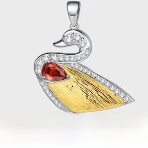 Detailed close-up of a S925 sterling silver swan pendant with gold plating and red zircon