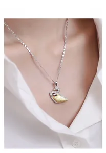 Detail of S925 sterling silver swan pendant with gold brushed finish and inlaid crystals