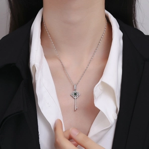 Collier clé en argent 925 avec pierre verte et pavé de zircons sur un modèle