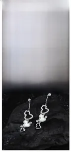 Detail view of S925 silver wulu tassel earrings with white shell and inlaid pavé diamonds