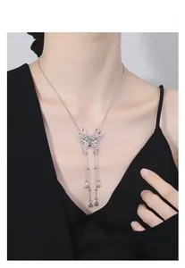 Détail du collier papillon argenté avec pompons en métal liquide sur le cou du mannequin