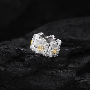 Bague marguerite en argent S925 avec détails dorés sur un socle en pierre noire