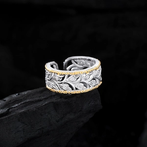 S925 sterling silver hollow leaf ring with gold edges and zircon accents on black rock