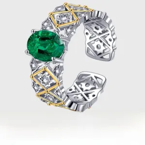 Detailed macro of vintage silver ring with emerald stone and gold-plated lace texture