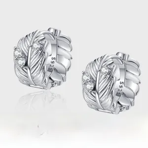 Vue détaillée des boucles d'oreilles plume en argent avec texture et petits zircons