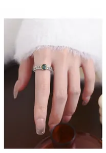 Close-up of a vintage 925 silver ring with an emerald-cut green stone and lace details