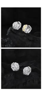 Détail macro de boucles d'oreilles plume en argent S925 doré avec incrustation de zircon