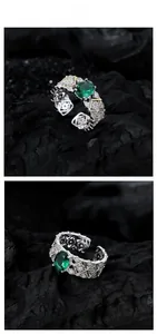 Macro detail of vintage emerald ring featuring intricate hollow lace and gold-plated edges