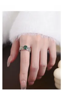 Close-up of vintage S925 silver ring with emerald stone and gold-plated lace details