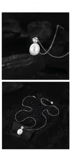 Détail macro d'un pendentif perle blanche en goutte sur une chaîne en argent sterling S925