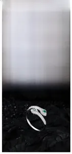 Gros plan d'une bague serpent en argent avec zircon émeraude et cristaux pavés fins