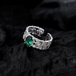Vintage S925 silver emerald ring with gold accents and hollow lace pattern on dark wood