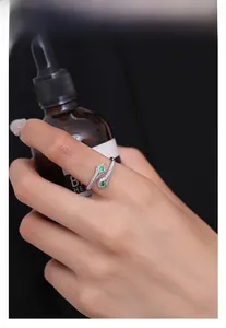 Détail d'une bague serpent en argent avec gemmes émeraude et pierres pavées étincelantes