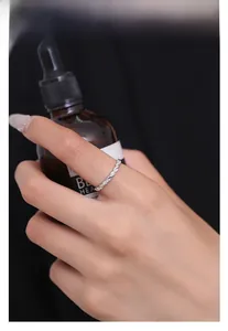 Dettaglio anello Mobius in argento S925 con pavé di zirconi su un dito femminile