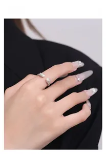 Détail d'une bague torsadée en argent S925 avec deux perles blanches portée par un mannequin