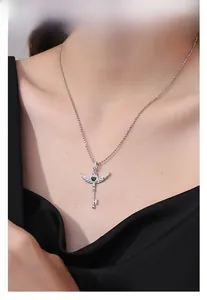 Dettaglio collana chiave ala d'angelo argento S925 con cuore verde su modella